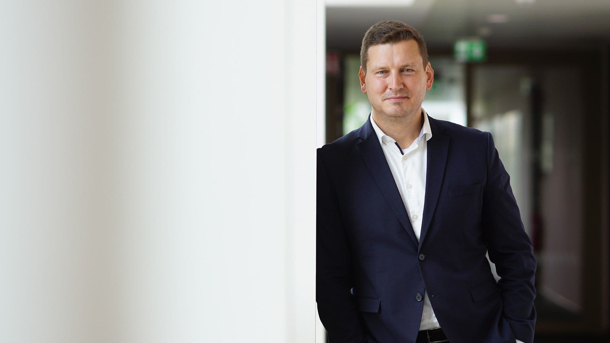 Mario Brandenburg im Porträt an einer Wand lehnend