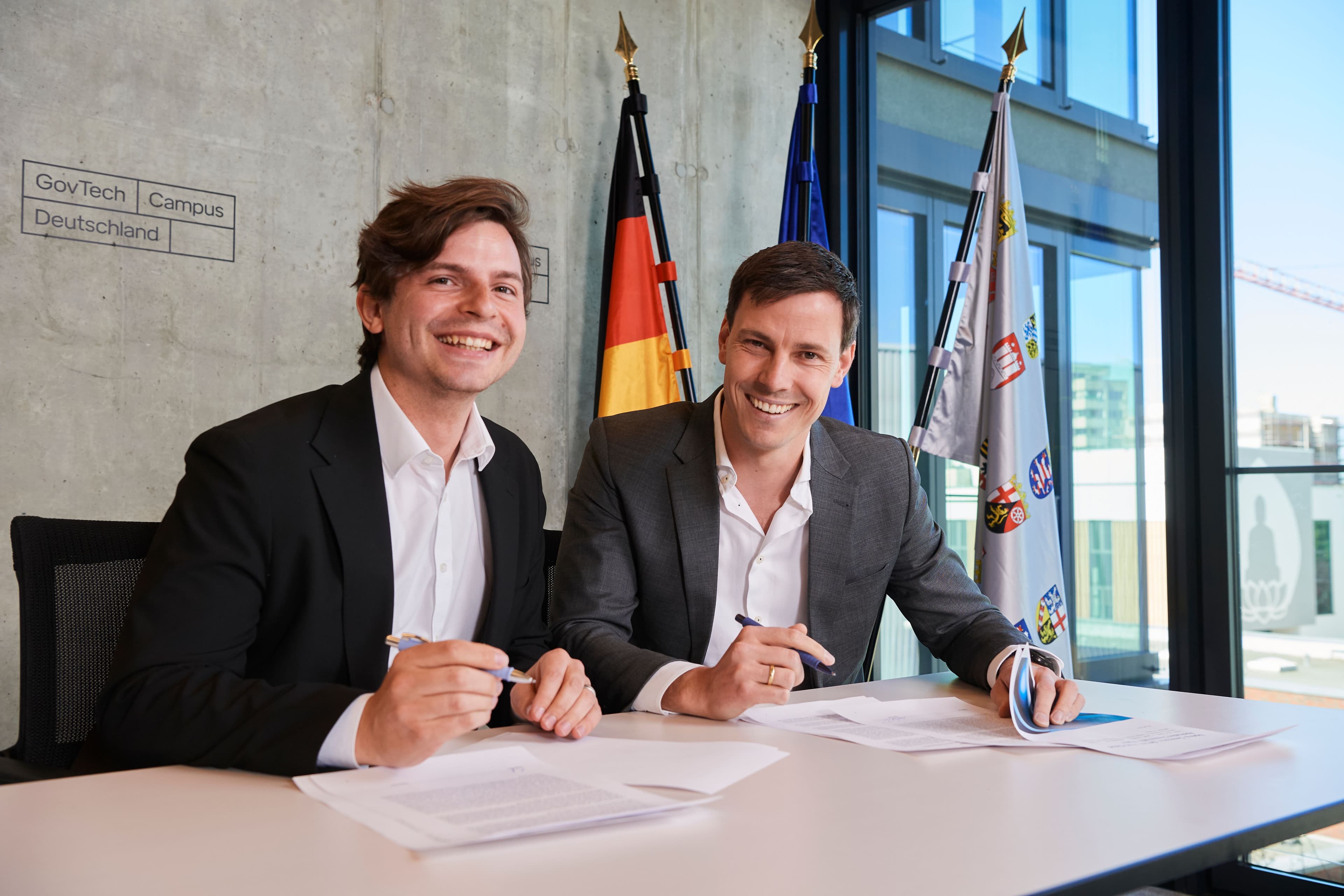 Codessphere-Gründer Elias Schneider, links im Bild, bei der Unterzeichnung mit einem Vertreter von Govtech Deutschland